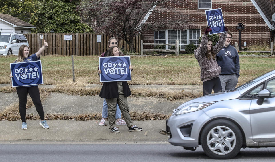 Lauren Payne, from left, Bella Karn, Victoria Garrard, Ella Bratcher and Connor Satterly encourage passing motorists to vote while standing on the sidewalk on W. Parrish Avenue, Tuesday, Nov. 5, 2019, in Owensboro, Ky. The five, all with the Wendell H. Ford Statesmanship Academy, and, other members of the organization, stood with signs at busy intersections in the city throughout election day. (Greg Eans/The Messenger-Inquirer via AP)