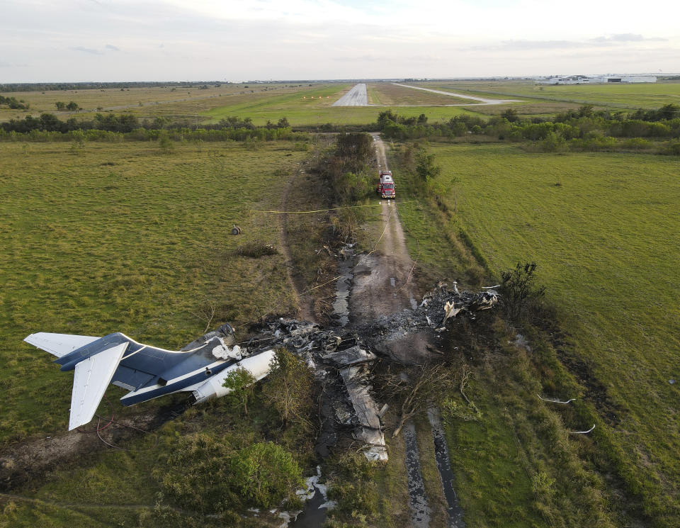 The remnants of an aircraft, which caught fire soon after a failed take-off attempt at Houston Executive Airport, are seen just north of Morton Road on Tuesday, Oct. 19, 2021, in Brookshire. Texas. (Godofredo A. Vásquez/Houston Chronicle via AP)