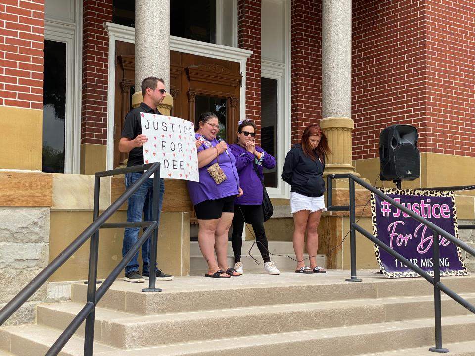 Wendy Washington, second from left, offers a prayer Monday during a rally at the old Lenawee County Courthouse in Adrian for Dee Warner, who has been missing for more than a year. Also pictured are, from left. Warner's nephew Parker Hardy of Tipton, holding a sign Washington brought to the rally; Stephanie Lemley of Tecumseh; and Hardy family friend Kathryn Adams of Clinton.