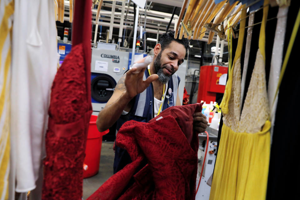 A spotter prepares to clean clothing at Rent the Runway's 