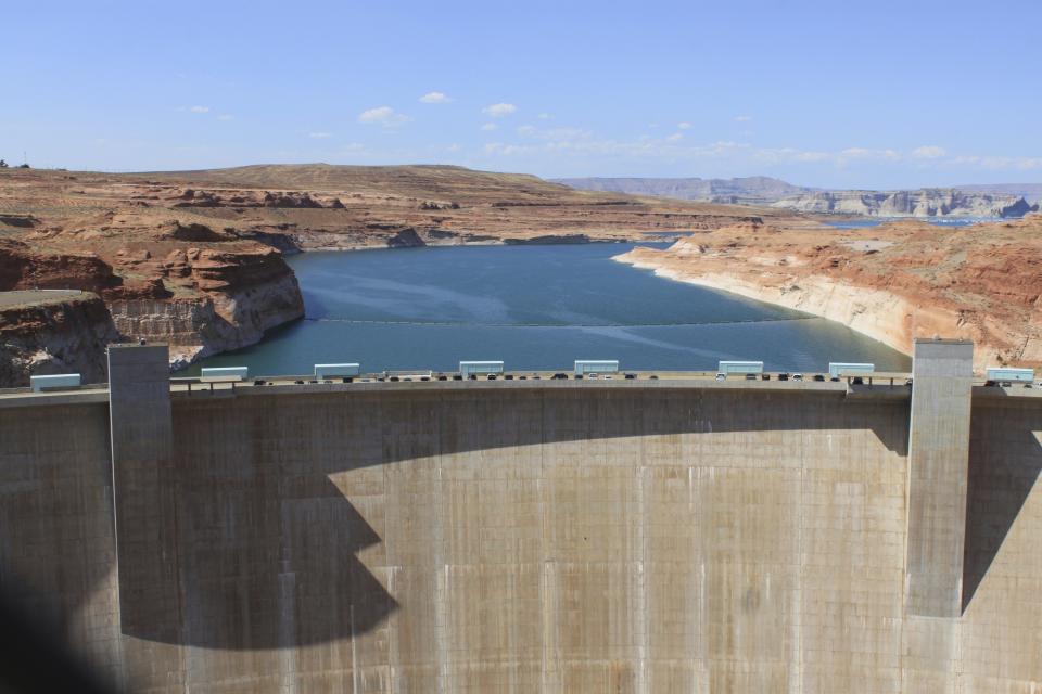 This Aug. 21, 2019 image shows Glen Canyon Dam in Page, Arizona. Environmental groups that have long pushed to bring down the dam along the Colorado River filed a lawsuit Tuesday, Oct. 2, 2019. They allege the U.S. Bureau of Reclamation ignored climate science when approving a 20-year operating plan for the dam. (AP Photo/Susan Montoya Bryan)