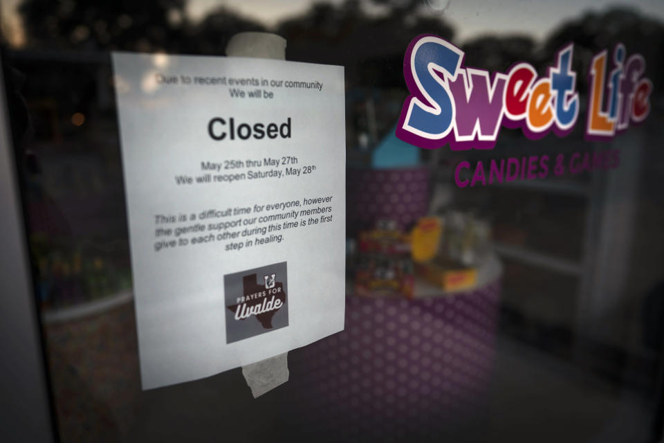 A sign is placed in front of a candy store informing customers of their closure in support of their community, which is grieving the loss of those killed during the mass shooting at Robb Elementary School on May 24, in Uvalde, Texas, Friday, May 27, 2022. (AP Photo/Wong Maye-E)