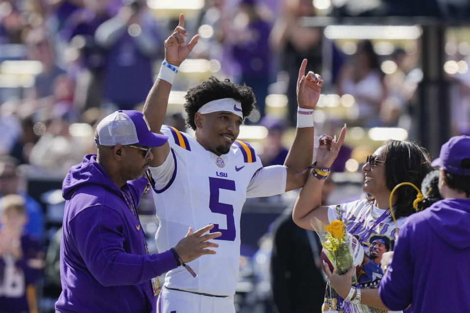 LSU quarterback Jayden Daniels (5) celebrates with his parents on senior day, for his final home game, before an NCAA college football game against Texas A&M in Baton Rouge, La., Saturday, Nov. 25, 2023. (AP Photo/Gerald Herbert)