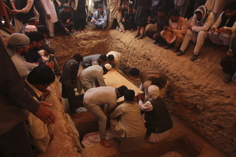 Afghans bury the bodies of victims of the Dubai City wedding hall bombing during a mass funeral in Kabul, Afghanistan, Sunday, Aug.18, 2019. The deadly bombing at the wedding in Afghanistan's capital late Saturday that killed dozens of people was a stark reminder that the war-weary country faces daily threats not only from the long-established Taliban but also from a brutal local affiliate of the Islamic State group, which claimed responsibility for the attack. (AP Photo/Rafiq Maqbool)