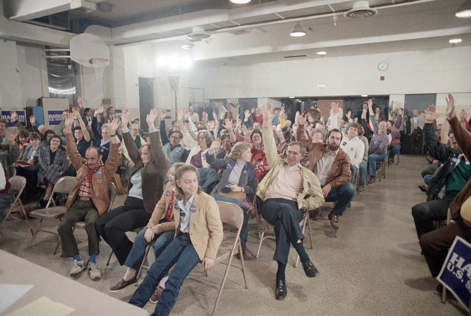 FILE - Hands go up to vote for former Vice President Walter Mondale on Monday night, Feb. 20, 1984, at a Democratic Precinct Caucus at St. Anthony's Church School in Des Moines. (AP Photo/Charles Bennett, File)