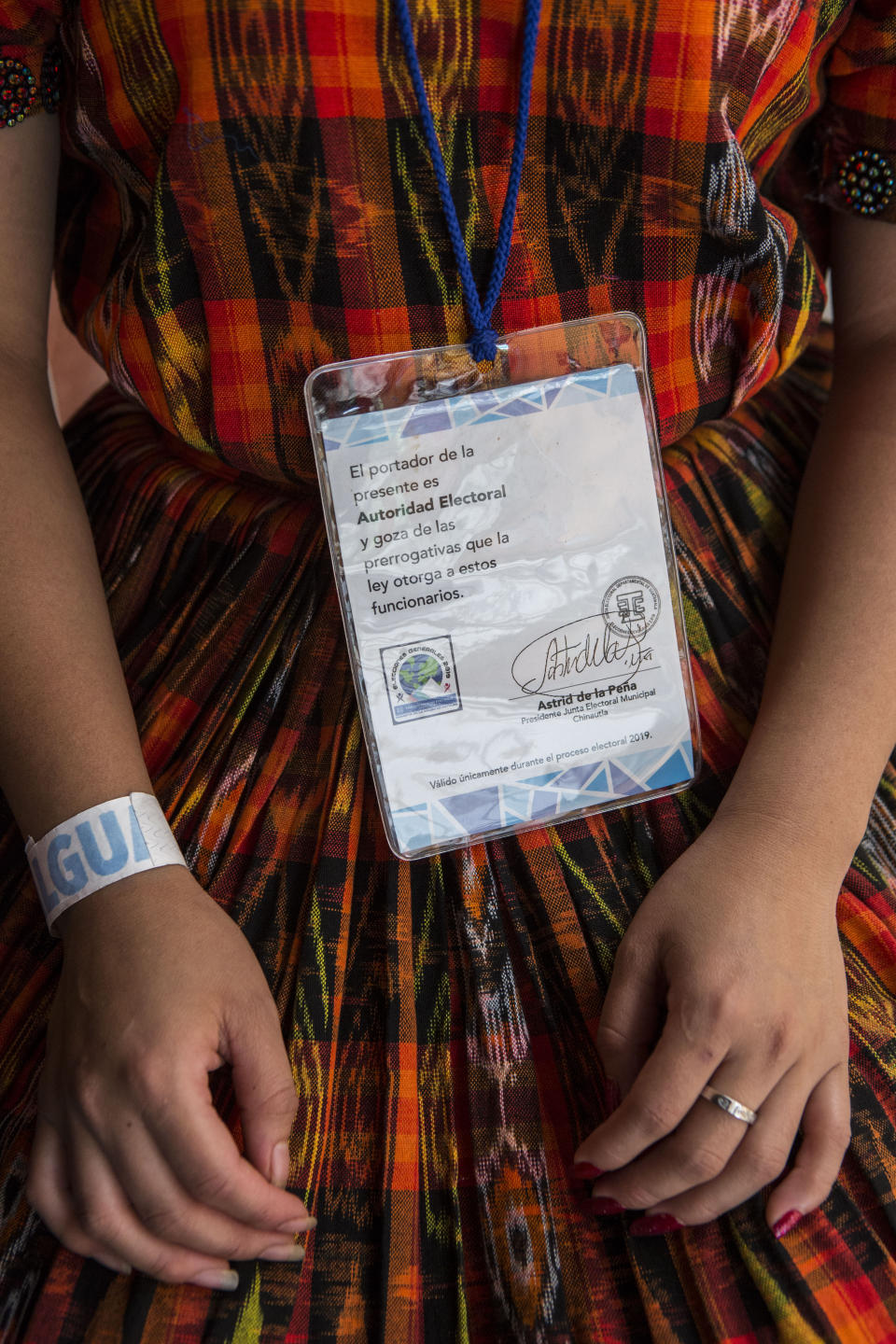 A woman shows her credential as an electoral worker at a polling station in Chinautla on the outskirts of Guatemala City, Sunday, August 11, 2019. Guatemalans go the polls Sunday in the second-round presidential runoff, pitting ex-first lady Sandra Torres against conservative Alejandro Giammattei in a nation beset by poverty, unemployment and emigration. (AP Photo/Oliver de Ros)