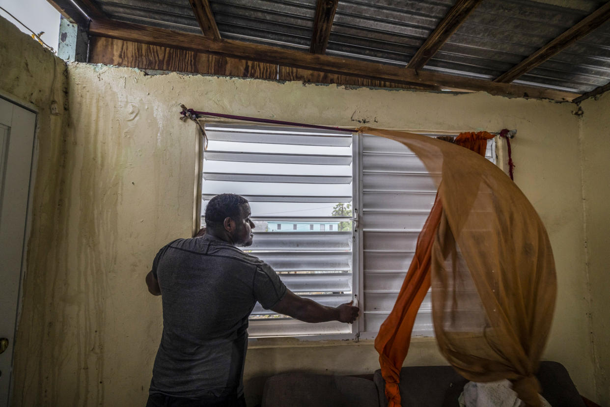 Nelson Cirino secures the windows of his home as the winds of Hurricane Fiona blow in Loiza, Puerto Rico, on Sept. 18, 2022. (Alejandro Granadillo / AP)