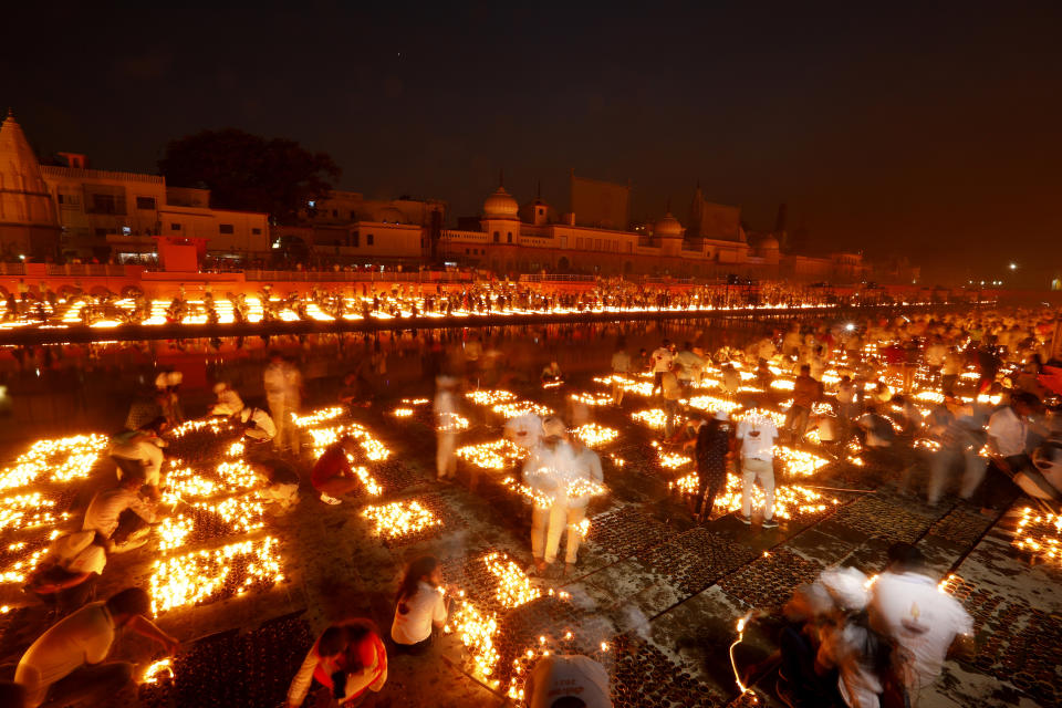 People light lamps on the banks of the river Saryu in Ayodhya, India, Wednesday, Nov. 3, 2021. Over 900,000 earthen lamps were lit and were kept burning for 45 minutes as the north Indian city of Ayodhya retained its Guinness World Record for lighting oil lamps as part of the Diwali celebration – the Hindu festival of lights. (AP Photo/Rajesh Kumar Singh)