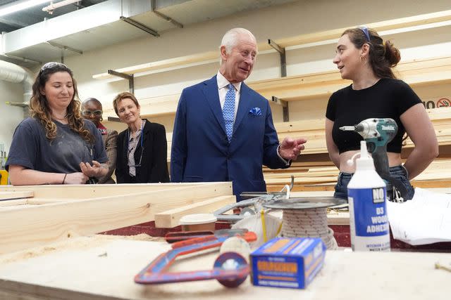 <p>JORDAN PETTITT/POOL/AFP via Getty</p> King Charles speaks with students at RADA on May 29, 2024.