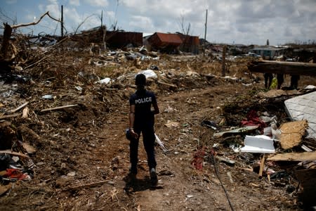FILE PHOTO: A police officer searches for the dead in the destroyed Mudd neighborhood after Hurricane Dorian hit the Abaco Islands in Marsh Harbour
