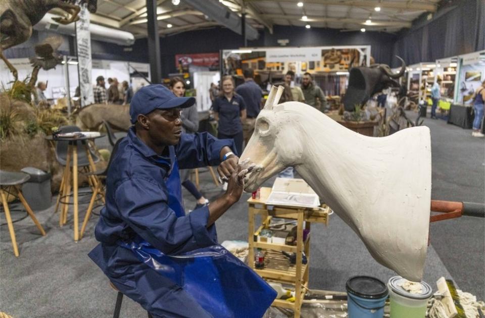 A taxidermy worker works on an antelope during the annual HuntEX exhibit.