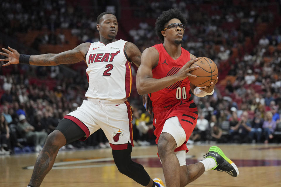 Portland Trail Blazers guard Scoot Henderson (00) looks to pass the ball as Miami Heat guard Terry Rozier (2) defends during the first half of an NBA basketball game, Friday, March 29, 2024, in Miami. (AP Photo/Jim Rassol)
