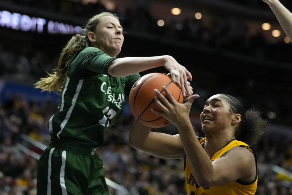 Cleveland State guard Carmen Villalobos (13) fights for a rebound with Iowa forward Hannah Stuelke, right, during the first half of an NCAA college basketball game, Saturday, Dec. 16, 2023, in Des Moines, Iowa. (AP Photo/Charlie Neibergall)