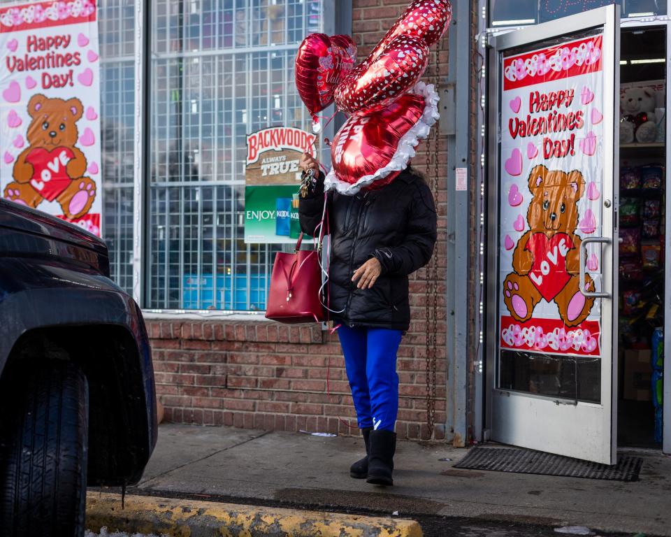 Evelyn Smiley exits a Dollar General with balloons in hand for Valentine's Day on Feb. 14, 2021, in Detroit. She got them for her great nieces and great nephews.