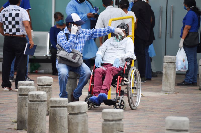 A man has his respirator mask adjusted outside Guasmo Sur General Hospital after Ecuador reported new cases of coronavirus disease (COVID-19), in Guayaquil