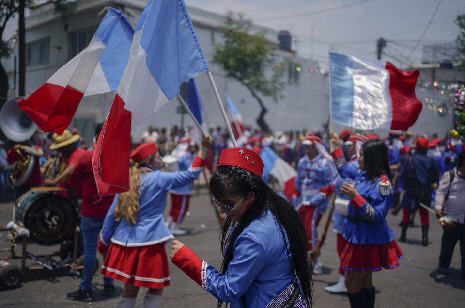 Women dance with French flags during a re-enactment of The Battle of Puebla as part of Cinco de Mayo celebrations in the Peñon de los Baños neighborhood of Mexico City, Thursday, May 5, 2022. Cinco de Mayo commemorates the victory of an ill-equipped Mexican army over French troops in Puebla on May 5, 1862. (AP Photo/Eduardo Verdugo)