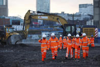 Britain's Prime Minister Boris Johnson, 2nd left, walks with apprentices during a tour of the Curzon Street railway station, where the new High Speed 2 (HS2) rail project is under construction, in Birmingham, England, Tuesday Feb. 11, 2020. Boris Johnson said his Cabinet had given the “green light” to the high-speed rail line that will link London with central and northern England, despite the huge cost prediction and opposition from environmentalists. (Eddie Keogh/Pool via AP)