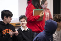 Central Bucks School District high school student Leo Burchell, center, talks with his friend and fellow student, Reed Vollrath left, as they wait for a school board meeting to begin in Doylestown, Pa., on Tuesday, Nov. 15, 2022. Over the last year, the Central Bucks School District’s board passed what it called a “neutrality” policy that bars social and political advocacy in classrooms — a measure opponents have seen as targeting Pride flags and other symbols teachers use to signal support for LGBTQ+ students. Reviews of the appropriateness of books have mostly targeted LGBTQ+ literature. (AP Photo/Ryan Collerd)