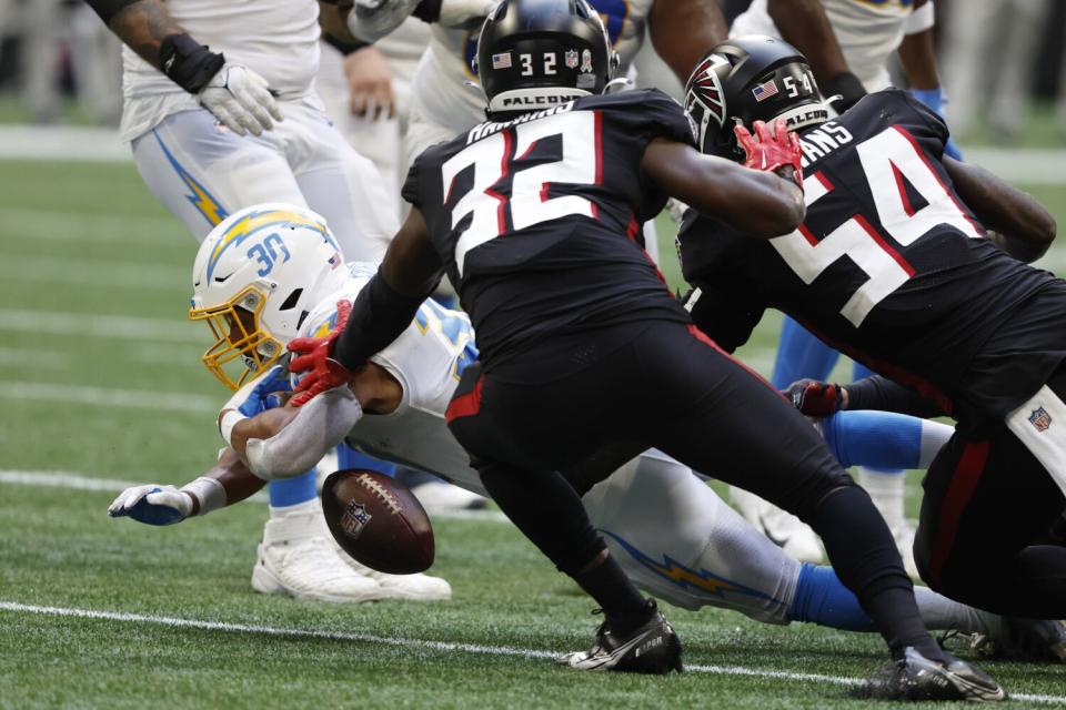 The Chargers' Austin Ekeler (30) fumbles before Atlanta recovered and fumbled the ball back to Los Angeles.