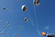 <p>One day after the deadly shooting at Marjorie Stonemason Douglas High School in Parkland, Fla., that left 17 dead and 14 injured, people gather for a memorial at Parkridge Church in Coral Springs, Fla., where balloons were released at the end of the vigil. (Photo: Carolyn Cole/Los Angeles Times via Getty Images) </p>