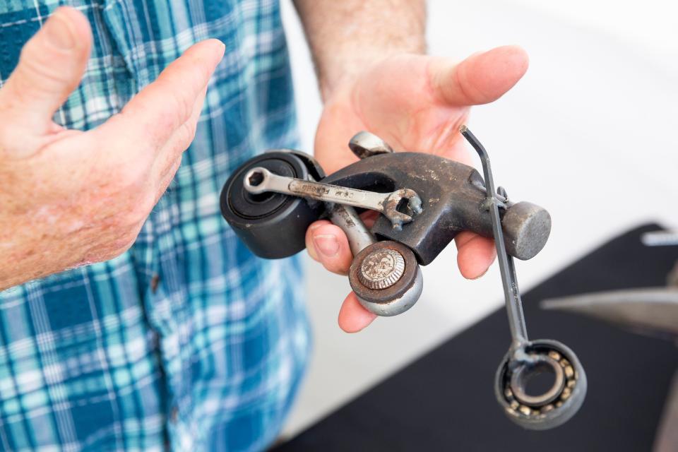 J.W. Burcham talks about this motorcycle piece he created using the head of a hammer and other pieces of tools and metal machinery during the Cooper-Young Festival in Midtown Memphis, on Saturday, September 16, 2023.