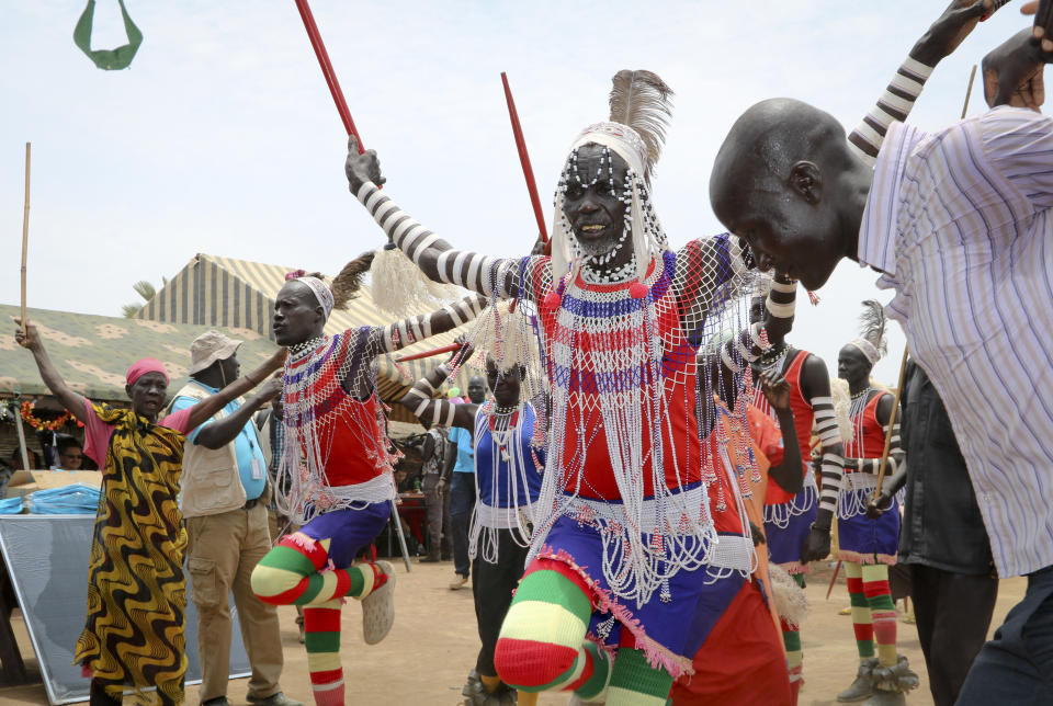 In this photo taken Tuesday, March 26, 2019, South Sudanese perform a traditional dance as they welcome donors who were launching a new joint education in emergencies initiative with the aim of providing daily meals to 75,000 children, in Aweil, Northern Bahr el Ghazal state, in South Sudan. Human rights activist Mia Farrow spoke to The Associated Press as she visited South Sudan again in her new role as envoy for the International Rescue Committee, helping the aid group to promote a global initiative to change the way humanitarian organizations approach malnutrition. (AP Photo/Sam Mednick)