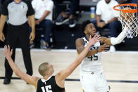 Utah Jazz's Donovan Mitchell, right, goes up for a shot against Denver Nuggets' Nikola Jokic during the second half of an NBA basketball first round playoff game, Monday, Aug. 17, 2020, in Lake Buena Vista, Fla. (AP Photo/Ashley Landis, Pool)