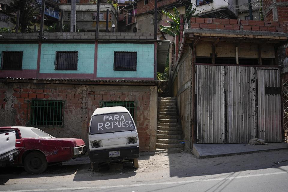 A derelict car with "For spare parts," written in Spanish on its windshield sits parked in the San Juan neighborhood of Caracas, Venezuela, Tuesday, April 19, 2022. Drivers try to coax a little more life out of aging vehicles in a country whose new car market collapsed and where few can afford to trade up for a better used one. (AP Photo/Matias Delacroix)