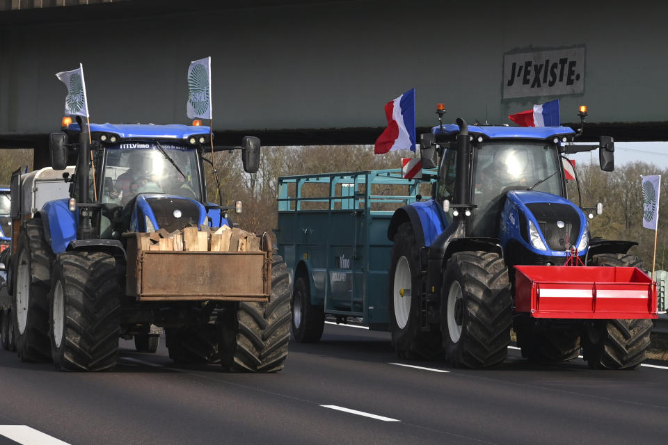 Farmers drive their tractors on a highway leading to Paris, Monday, Jan. 29, 2024 near Compiegne, north of Paris. Protesting farmers vowed to encircle Paris with tractor barricades and drive-slows on Monday, aiming to lay siege to France's seat of power in a battle with the government over the future of their industry, which has been shaken by repercussions of the Ukraine war. (AP Photo/Matthieu Mirville)