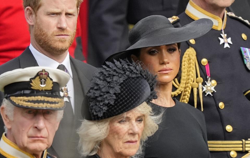 FILE - Britain's King Charles III, from bottom left, Camilla, the Queen Consort, Prince Harry and Meghan, Duchess of Sussex watch as the coffin of Queen Elizabeth II is placed into the hearse following the state funeral service in Westminster Abbey in central London Monday Sept. 19, 2022. Prince Harry has defended his memoir that lays bare rifts inside Britain’s royal family. He says in TV interviews broadcast Sunday that he wanted to “own my story” after 38 years of “spin and distortion” by others. (AP Photo/Martin Meissner, Pool, File)