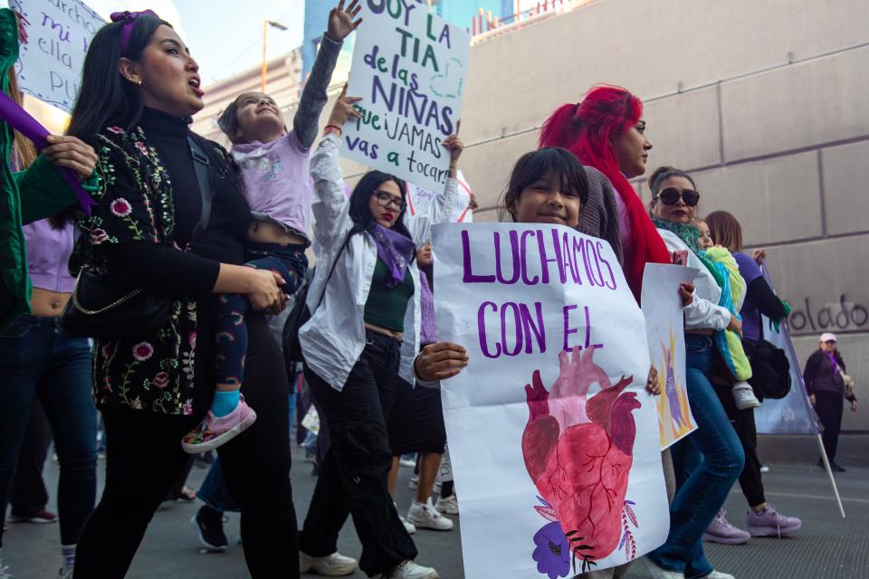 Nayeli Macías, left, marches with her daughters, Layla, 4, and Ximena, 8, as they enter the 16 de Septiembre tunnel a women's march in Ciudad Juárez, March 8, 2024. Macías said that she wants her daughters to learn to speak up for their rights.