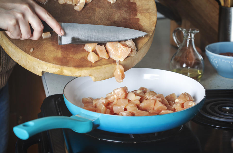 Woman cooking chicken breast.