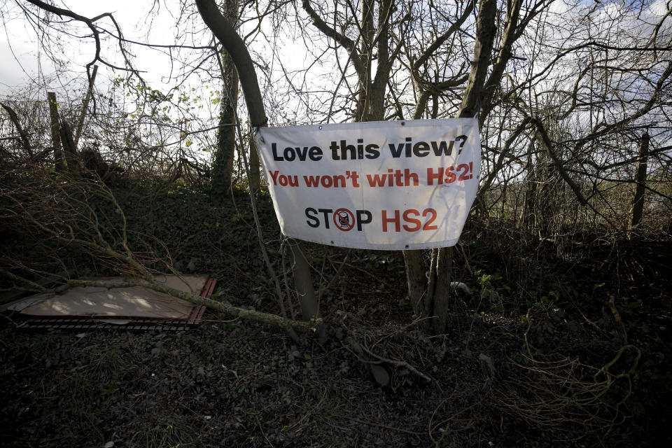 A protest sign is displayed by a roadside protest camp across the street from a High Speed 2 (HS2) rail line compound near the village of Harefield in north west London, Tuesday, Feb. 11, 2020. Britain's Conservative government is set to approve a contentious, expensive plan for a high-speed rail line linking London with central and northern England, despite opposition from environmentalists and even some members of the governing party. (AP Photo/Matt Dunham)