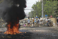 FILE - In this March 30, 2021, file photo, anti-coup protesters stand beside burning tires as they fortify their position against the military during a demonstration in Yangon, Myanmar. One hundred days since their takeover, Myanmar’s ruling generals maintain just the pretense of control over the country. There are fears the military takeover is turning Myanmar into a failed state. (AP Photo, File)