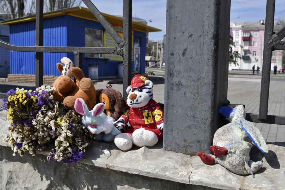 Flowers and toys were left on a fence at the railway station in Kramatorsk, Ukraine, Monday, April 11, 2022. A missile strike killed at least 50 people and wounded dozens more when a rocket hit the railway station on Friday, April 8. (AP Photo/Andriy Andriyenko)