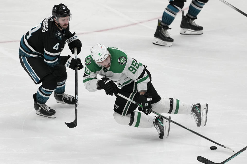 Dallas Stars center Matt Duchene (95) reaches for the puck in front of San Jose Sharks defenseman Kyle Burroughs (4) during the third period of an NHL hockey game in San Jose, Calif., Tuesday, March 26, 2024. (AP Photo/Jeff Chiu)