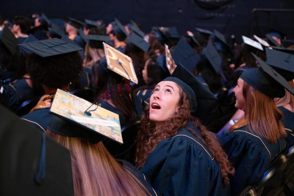 Summer Camporesi looks up at the big screen as images of the graduates crossing the stage are shown during the 2024 UC Davis commencement ceremony on Friday.