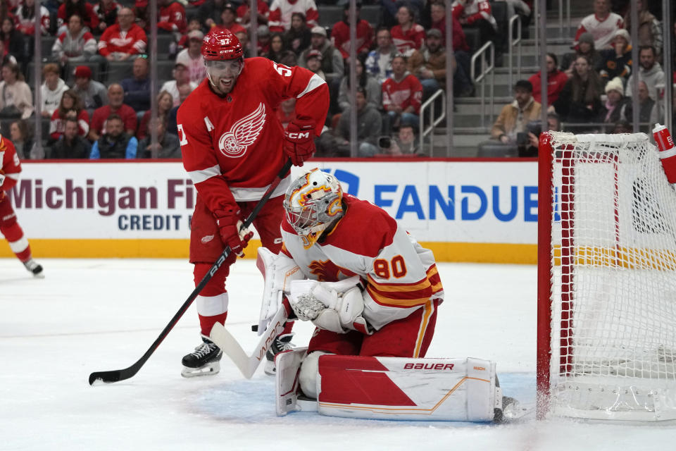 Calgary Flames goaltender Dan Vladar (80) stops a Detroit Red Wings left wing David Perron (57) shot in the first period of an NHL hockey game Sunday, Oct. 22, 2023, in Detroit. (AP Photo/Paul Sancya)