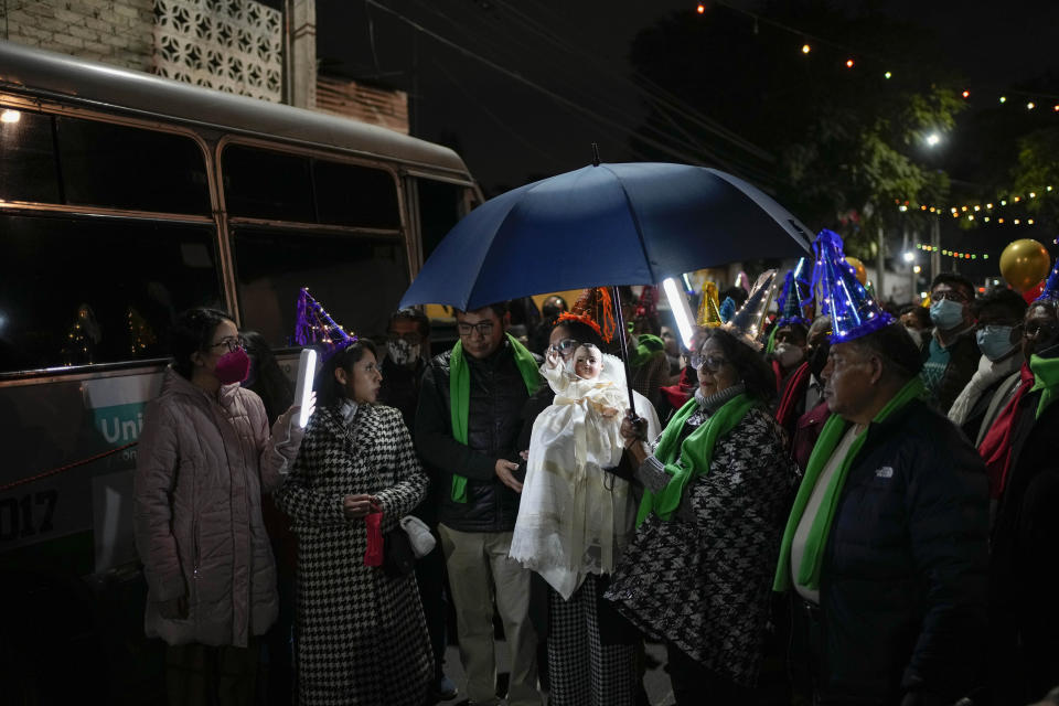 Residents carry a statue of baby Jesus in the procession of "Niñopan" during a Christmas "posada," which means lodging or shelter, in the Xochimilco borough of Mexico City, Wednesday Dec. 21, 2022. For the past 400 years, residents have held posadas between Dec. 16 and 24, when they take statues of baby Jesus in procession to church for Mass to commemorate Mary and Joseph's cold and difficult journey from Nazareth to Bethlehem in search of shelter. (AP Photo/Eduardo Verdugo)