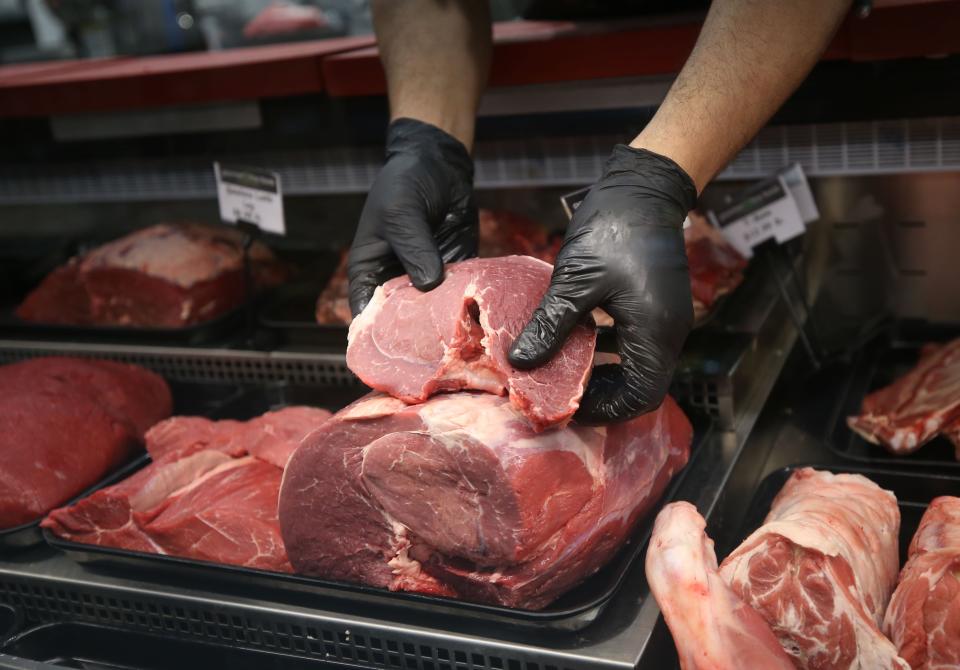 Abdulhak Mounacer places freshly cut lamb ribs into the meat case at Gourmet Fine Foods by Istanbul Market. All meats there are halal.