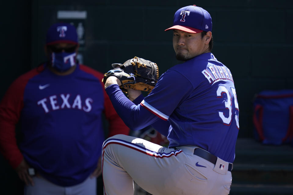 El lanzador abridor de los Rangers de Texas Kohei Arihara calienta antes de su segundo juego en el campamento de primavera ante los Cachorros de Chicago el lunes 8 de marzo del 2021. (AP Photo/Ashley Landis)