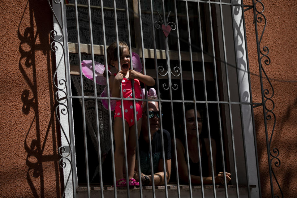 A costumed child watches the Carmelitas street party on the first day of Carnival in Rio de Janeiro, Brazil, Friday, Feb. 17, 2023. (AP Photo/Bruna Prado)