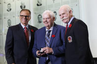 Hockey Hall of Fame 2023 inductee Ken Hitchcock, center, receives his Hockey Hall of Fame ring from Mike Gartner, left, and Lanny McDonald as he's inducted into the Hall in Toronto Friday, Nov. 10, 2023. (Cole Burston/The Canadian Press via AP)