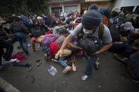 Honduran migrants hoping to reach the U.S. scramble to cross the border patrolled by Guatemalan soldiers, in El Florido, Guatemala, Saturday, Jan. 16, 2021. The migrants pushed their way into Guatemala Friday night without registering, a portion of a larger migrant caravan that had left the Honduran city of San Pedro Sula before dawn, Guatemalan authorities said. (AP Photo/Sandra Sebastian)