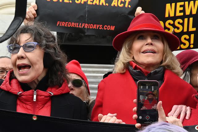 <p>EVA HAMBACH/AFP via Getty Images</p> Lily Tomlin and Jane Fonda hold hands as they lead a climate protest on the steps of the US Capitol in Washington, D.C. on December 27, 2019.