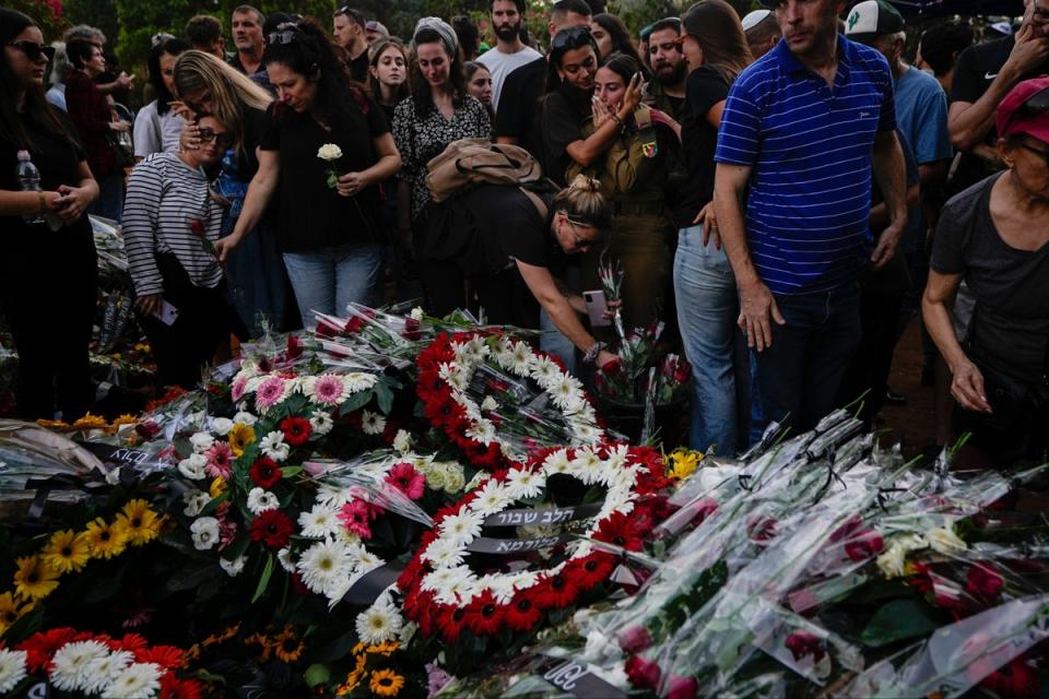 Mourners gather around the graves of Sgt. Yam Goldstein and her father killed by Hamas on 7 October (AP)