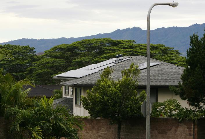 A view of houses with solar panels in the Mililani neighbourhood on the island of Oahu in Mililani, Hawaii, December 15, 2013. A new rule went into effect in September that requires homeowners on Oahu - Hawaii's most populous island - to get the utility's approval before installing photovoltaic rooftop solar systems. In areas like Mililani, the utility's power circuits have reached a threshold where it would be dangerous to add PV systems without investing in upgrades to the distribution system. Picture taken December 15, 2013. To match Analysis SOLAR-HAWAII/ REUTERS/Hugh Gentry (UNITED STATES - Tags: ENERGY BUSINESS)