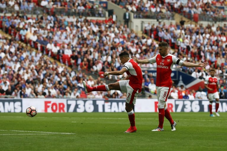 Arsenal's Chilean striker Alexis Sanchez (L) shoots to score the opening goal against Chelsea at their English FA Cup final at Wembley stadium in London on May 27, 2017