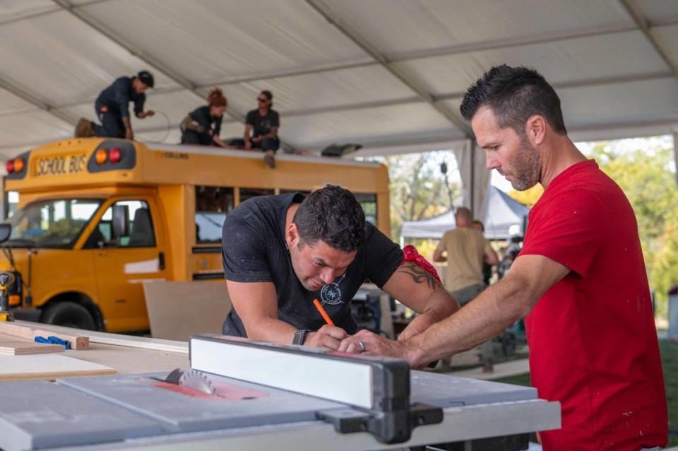 Igor Tomas, left and Travis Dean worked together Tuesday to measure out the exact amount of wood they would need for paneling inside an RV they’re renovating for the reality show “Gutted” at Camp Branch in Smithville.