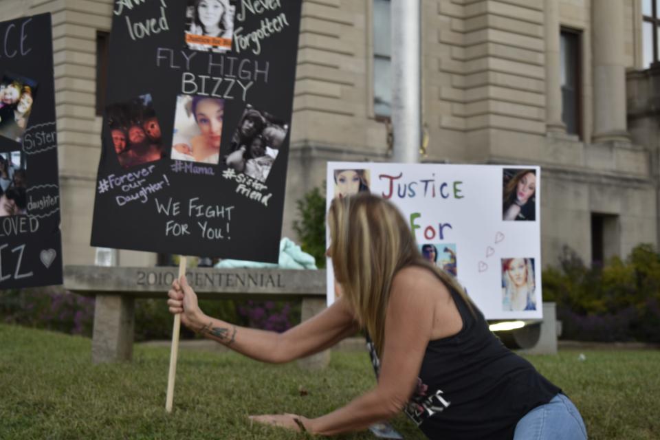 Vickie Edwards of Spencer places signs at the Owen County Courthouse seeking justice for the death of Elizabeth "Bizzy" Stevens, whose body was found on the side of the road in 2021.